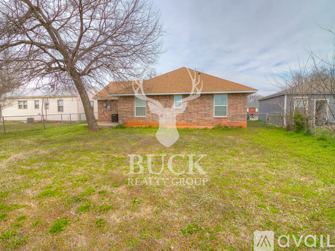 A house with a tree in front of it and a Buck Realty Group logo overlay.