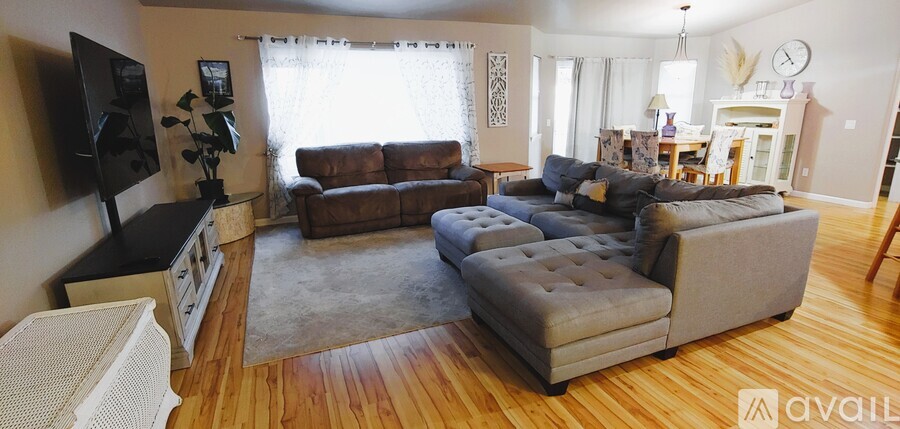 A living room with a grey couch and a brown couch.