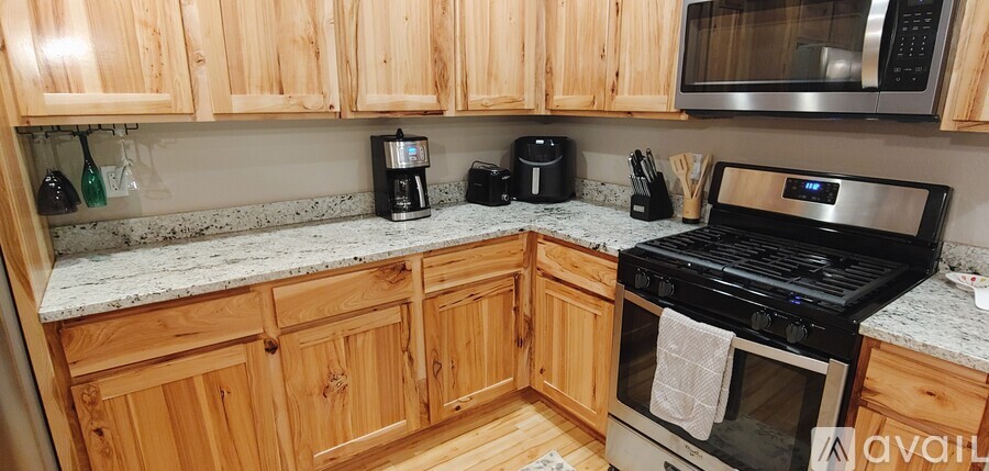 A kitchen with wooden cabinets and a black stove top oven.
