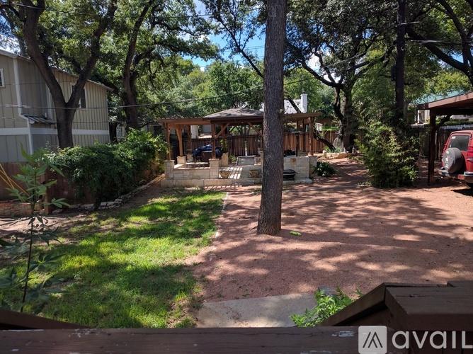 A backyard with a gazebo and a tree.