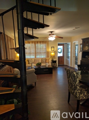 A living room with a leopard print chair and a wooden floor.