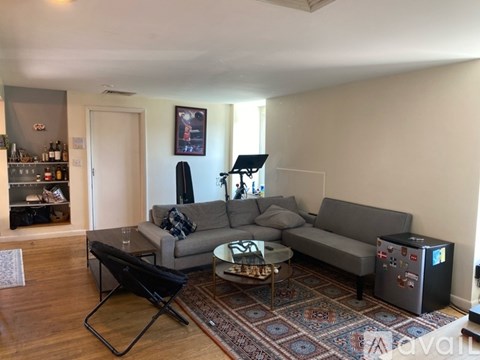 A living room with a grey couch and a black chair.