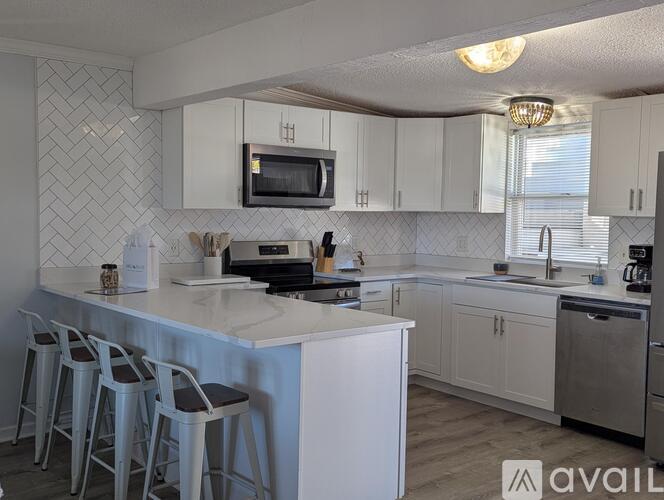 A kitchen with white cabinets and a black stove top.