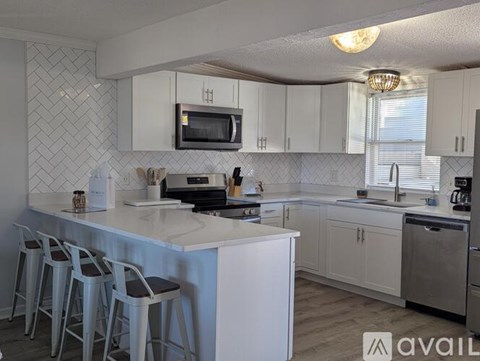 A kitchen with white cabinets and a black stove top.