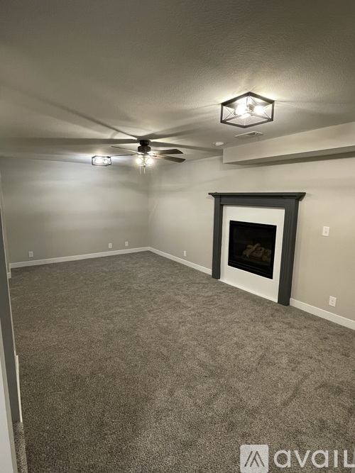 A living room with a fireplace and a ceiling fan.
