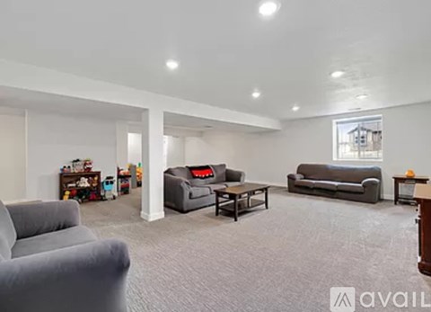 A living room with grey carpet and furniture.
