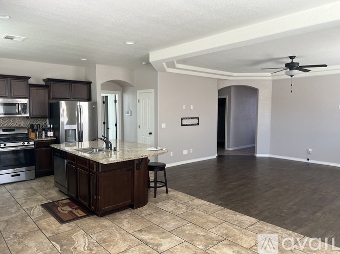 A kitchen with a marble countertop and a ceiling fan.