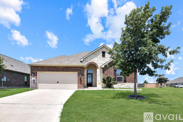 A house with a garage and a driveway in front of it.