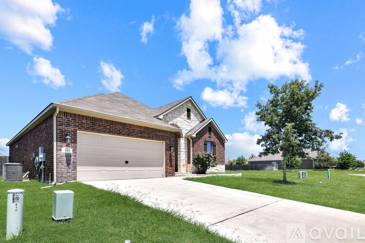 A house with a garage and a driveway in front of it.