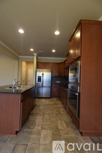 A kitchen with brown cabinets and a tile floor.