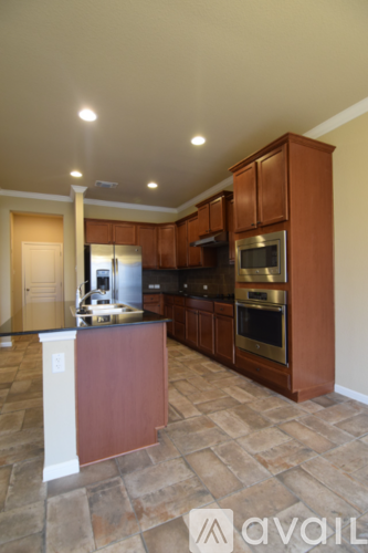 A kitchen with brown cabinets and a tiled floor.