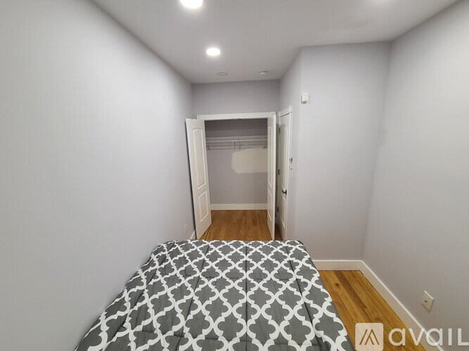 A bedroom with a bed and a doorway leading to another room.