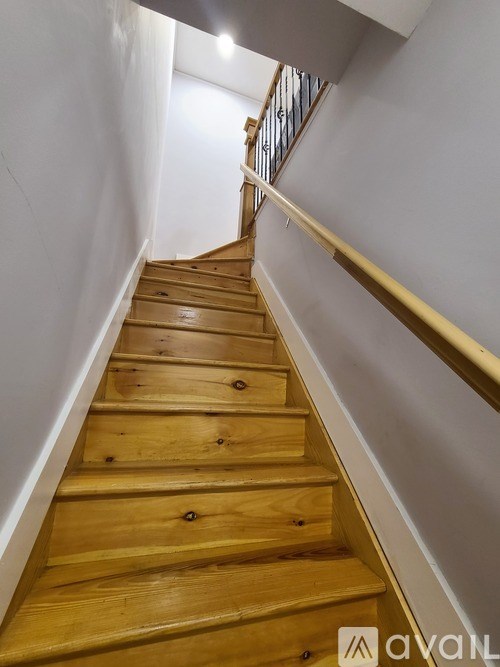 A wooden staircase with a metal railing.