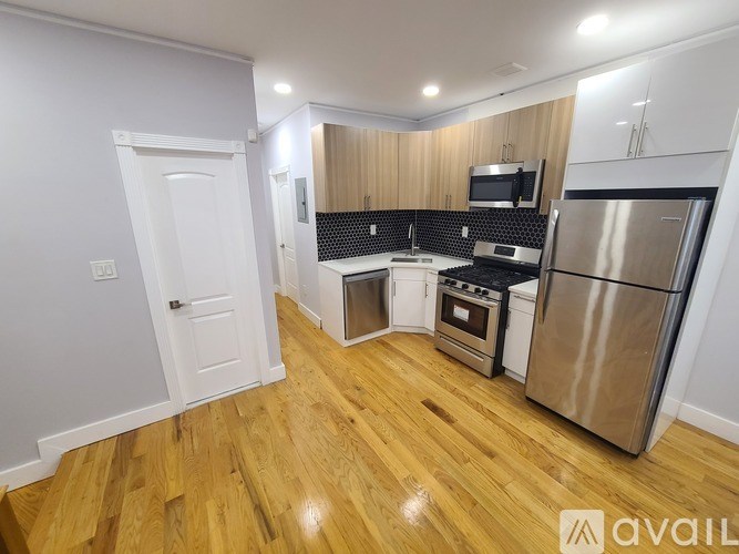 A kitchen with wooden floors and stainless steel appliances.