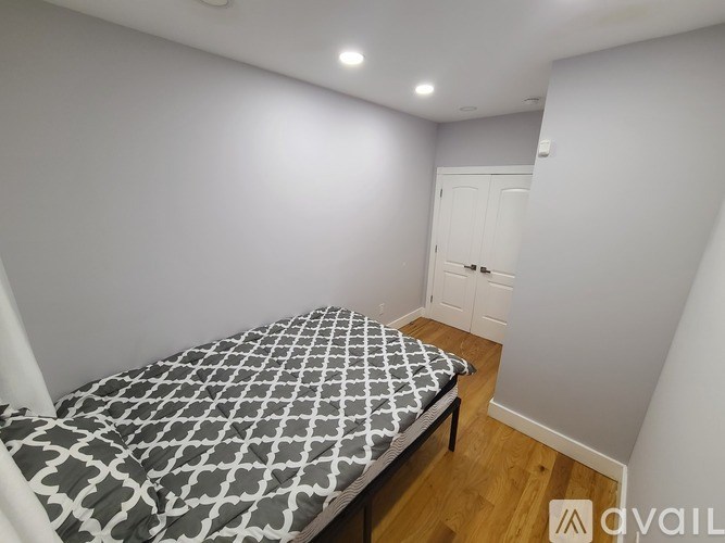 A bedroom with a bed and a wooden floor.