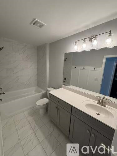 A bathroom with a marble tile floor and a white sink.