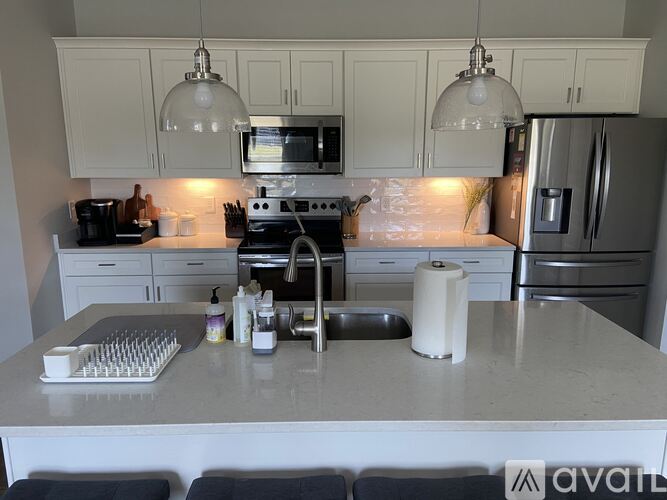 A kitchen with white cabinets and a granite countertop.