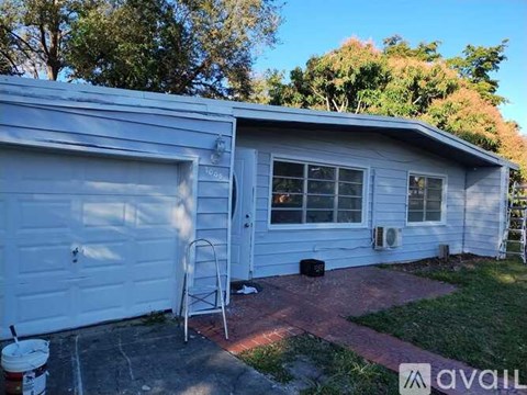 A house with a white garage door and a brick walkway leading to it.
