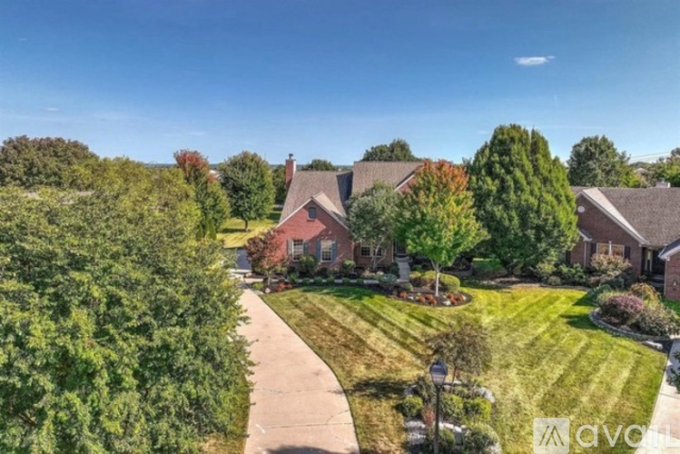 A house with a lawn and trees in front of it.