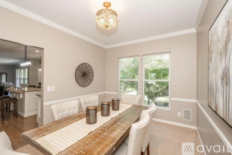 A well-lit dining room with a wooden table and chairs.