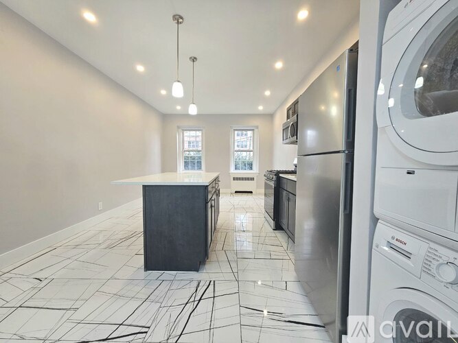 A kitchen with a black and white floor and a large island in the middle.