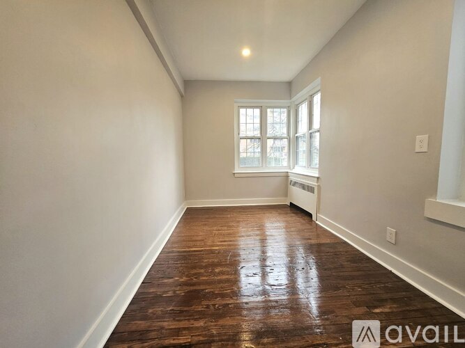 A room with wooden flooring and a window.