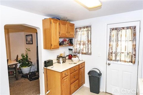 A kitchen with wooden cabinets and a white countertop.
