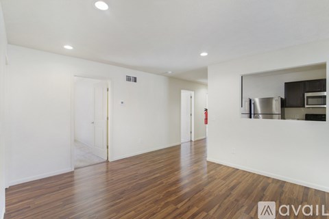 A spacious room with wooden floors and white walls.