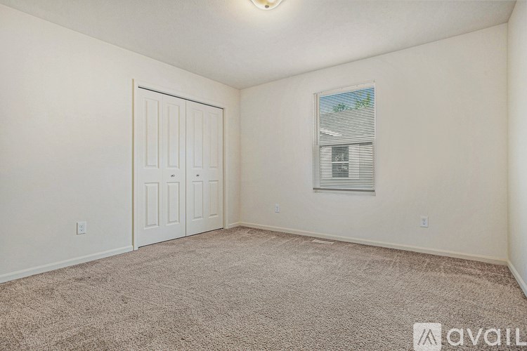 A room with a carpeted floor and a white door.