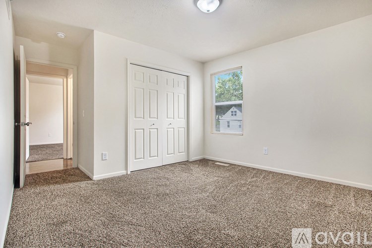 A room with a carpeted floor and a white door.