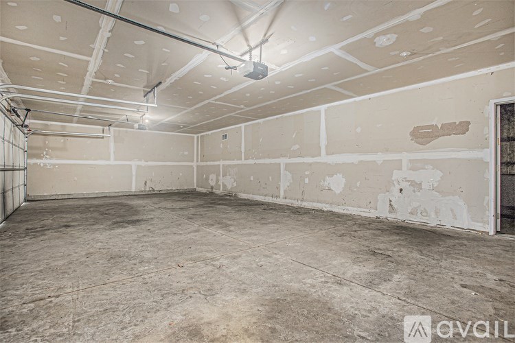 A large empty room with a concrete floor and exposed ceiling beams.