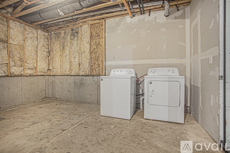 A room with two washing machines and a wall covered in insulation.
