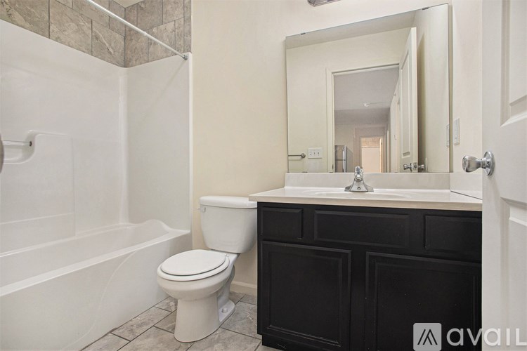 A bathroom with a toilet, sink, and bathtub.