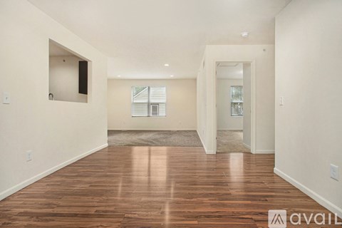 A spacious room with wooden floors and white walls.
