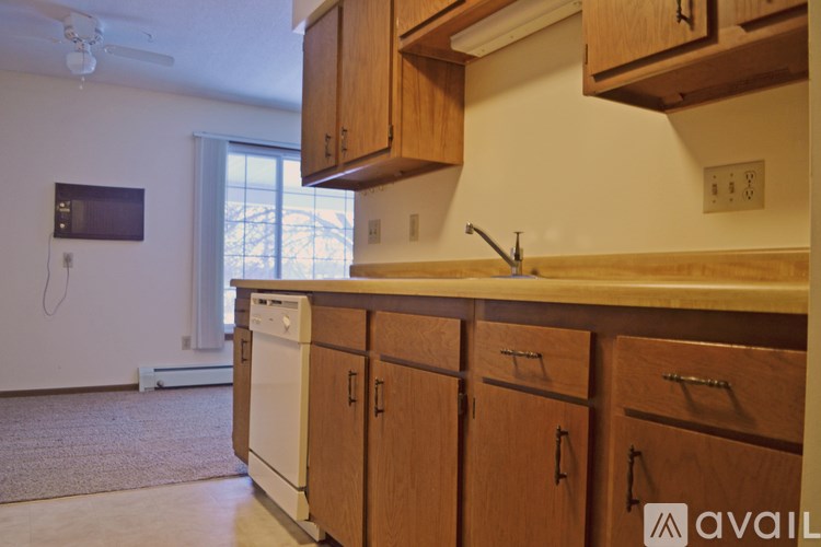 A kitchen with wooden cabinets and a washing machine in the background.
