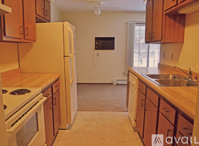 A kitchen with wooden cabinets and a white refrigerator.