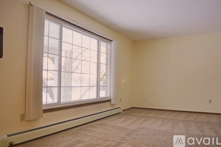 A room with a large window and carpeted floor.