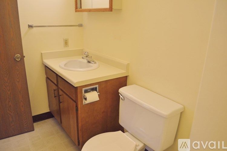 A bathroom with a toilet, sink, and mirror.