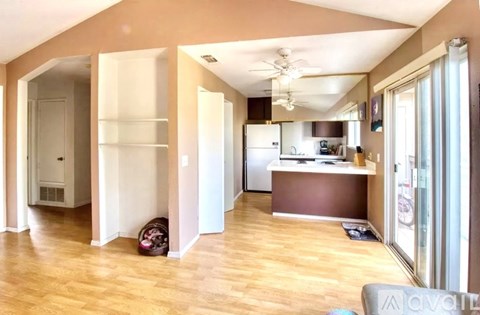 A kitchen area with a refrigerator, sink, and cabinets.
