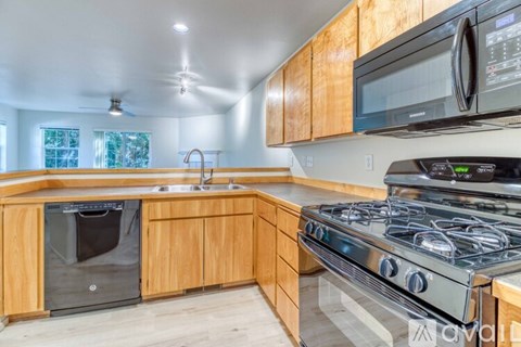 A kitchen with wooden cabinets and a stainless steel stove.