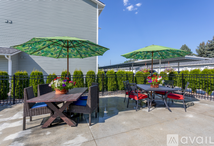 A patio with a table and chairs under green umbrellas.