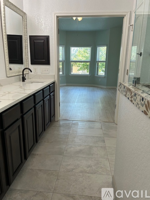 A bathroom with a marble floor and a white sink vanity.