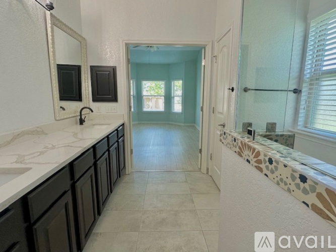 A bathroom with a sink, mirror, and tiled floor.