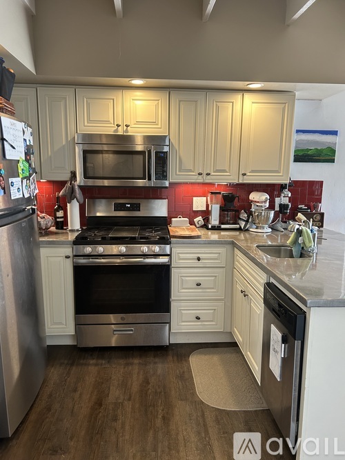 A kitchen with a stove top oven and a refrigerator.