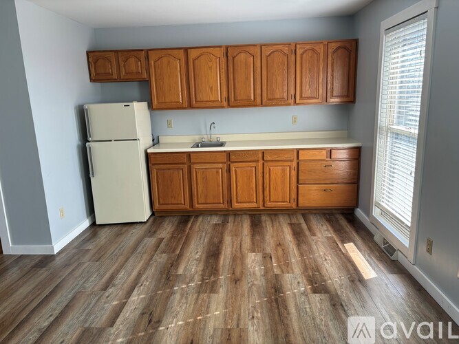 A kitchen with wooden cabinets and a white refrigerator.