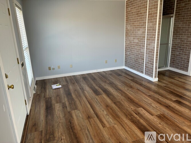 A room with wooden flooring and a white door.