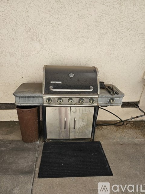 A charcoal grill is placed on a metal stand outside.