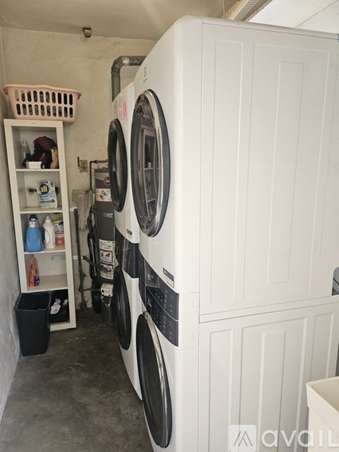 A white washing machine is in a small laundry room.