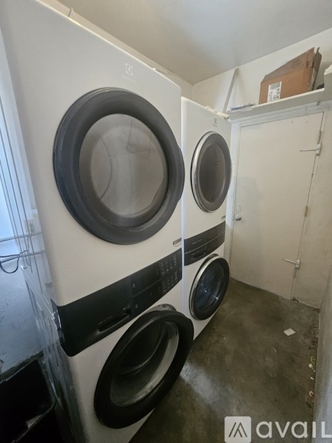 A white and black front load washing machine in a small room.
