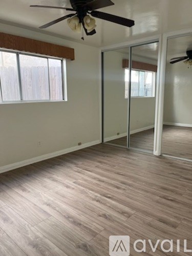 A room with a ceiling fan and a sliding glass door.